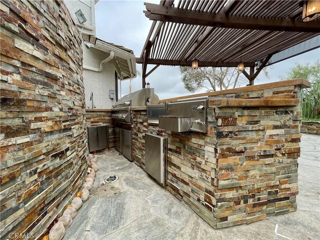 view of patio / terrace featuring a pergola and an outdoor kitchen