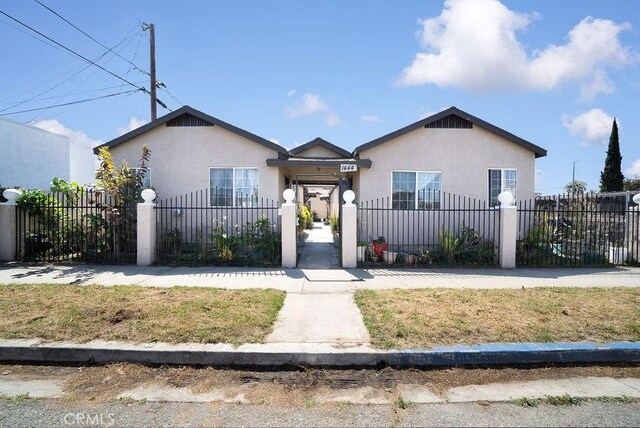 view of front facade featuring stucco siding and a fenced front yard