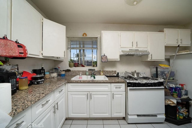 kitchen featuring white cabinets, range, under cabinet range hood, and a sink