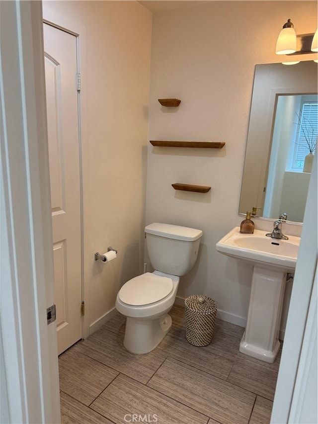 8823 Jacaranda Unit F, Montclair, CA 91763 - bathroom featuring toilet, baseboards, and wood finished floors