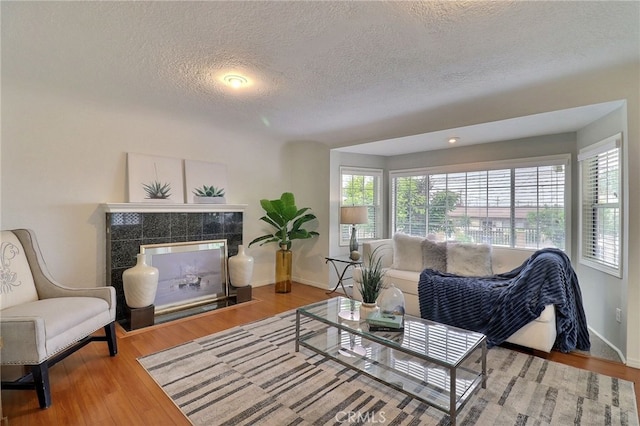 living area with baseboards, wood finished floors, and a textured ceiling