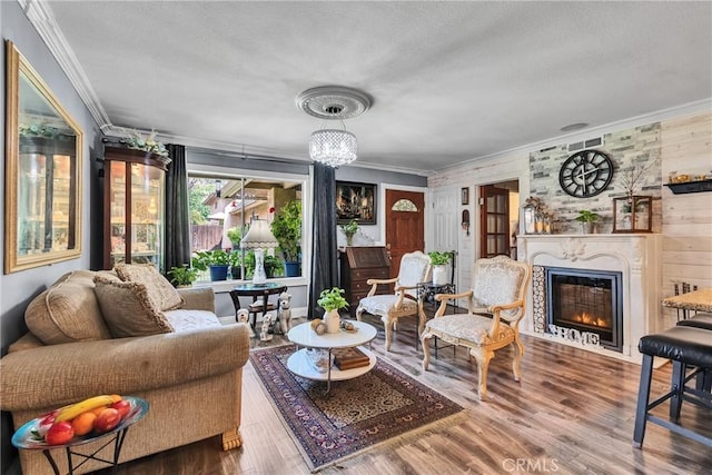 living area featuring a fireplace with flush hearth, a textured ceiling, and crown molding