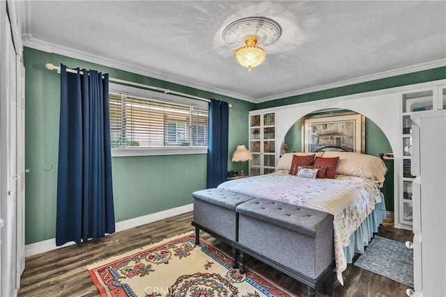 bedroom with baseboards, ornamental molding, and wood finished floors