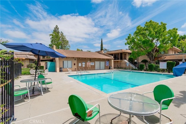 pool featuring fence and a patio area