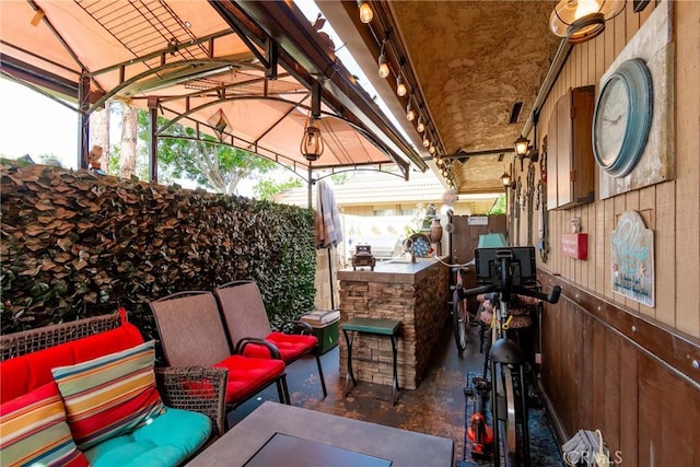 view of patio / terrace featuring fence, an outdoor bar, a gazebo, and an outdoor living space