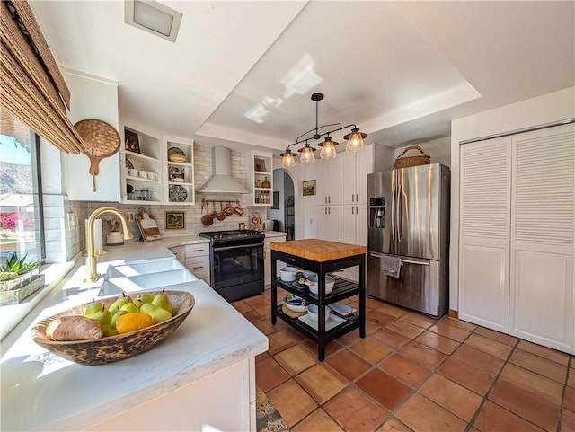 48143 Calle Seranas Ln, Quinta, CA 92253 - kitchen featuring wall chimney exhaust hood, arched walkways, black range with electric stovetop, open shelves, and stainless steel refrigerator with ice dispenser