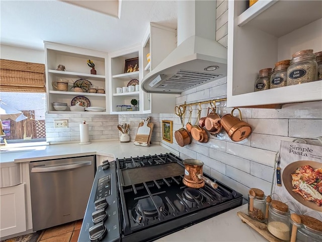 48143 Calle Seranas Ln, Quinta, CA 92253 - kitchen with stainless steel dishwasher, tasteful backsplash, open shelves, light countertops, and wall chimney exhaust hood