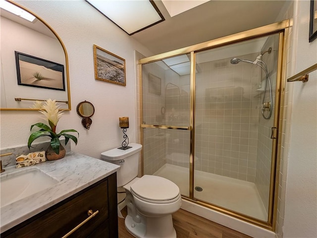 48143 Calle Seranas Ln, Quinta, CA 92253 - bathroom with wood finished floors, vanity, toilet, and a stall shower