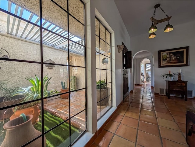 48143 Calle Seranas Ln, Quinta, CA 92253 - hall with arched walkways, vaulted ceiling, visible vents, and tile patterned flooring