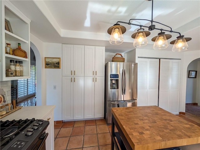 48143 Calle Seranas Ln, Quinta, CA 92253 - kitchen with arched walkways, butcher block countertops, white cabinetry, gas stove, and stainless steel refrigerator with ice dispenser