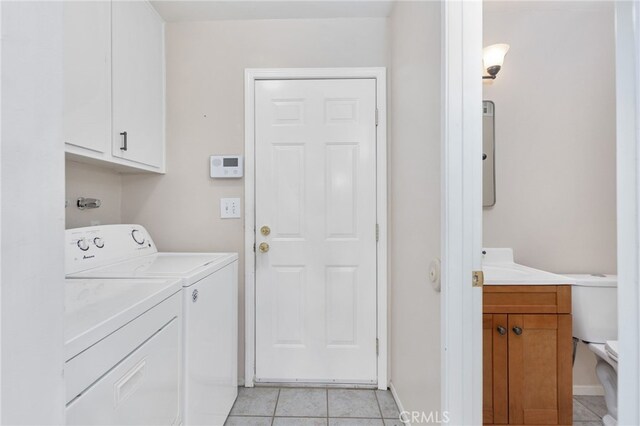 26481 Jamestown Dr, Menifee, CA 92586 - washroom with independent washer and dryer, light tile patterned floors, and cabinet space