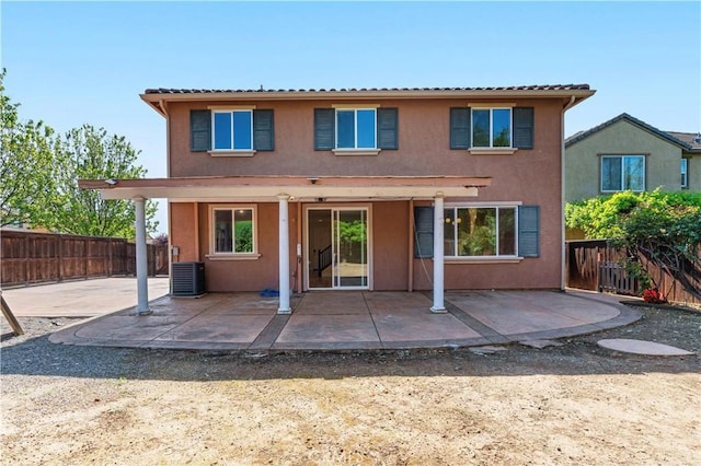 back of house featuring a patio area, central AC, a fenced backyard, and stucco siding