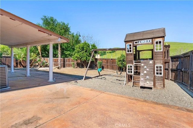 view of play area with a fenced backyard and a patio