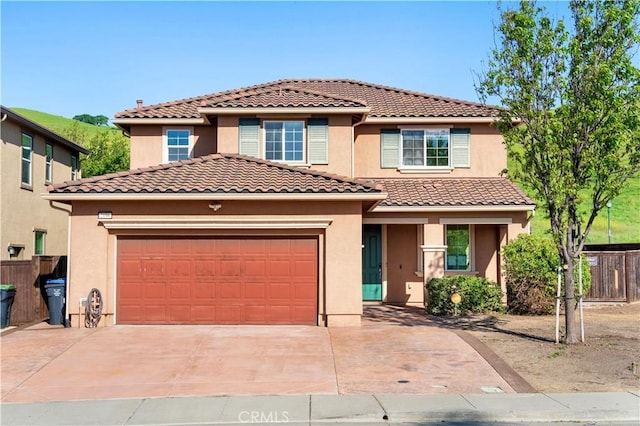 view of front of home featuring stucco siding, an attached garage, driveway, and fence