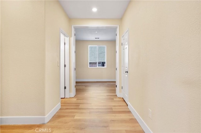 hall featuring recessed lighting, light wood finished floors, and baseboards