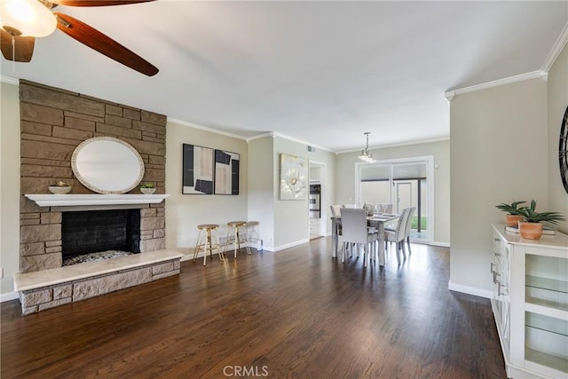 living area featuring wood finished floors, ornamental molding, baseboards, and ceiling fan