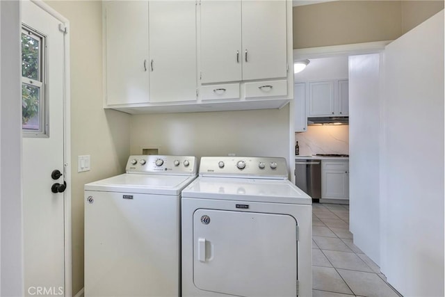 laundry room with washing machine and dryer, cabinet space, and light tile patterned floors