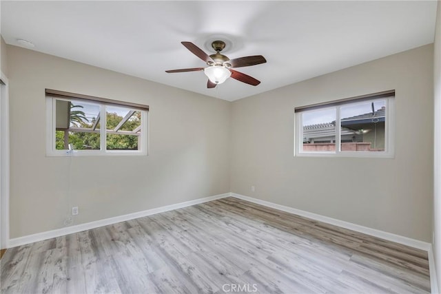 empty room with baseboards, a ceiling fan, and wood finished floors
