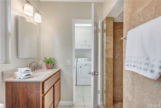 bathroom featuring tile patterned floors, vanity, independent washer and dryer, and a tile shower