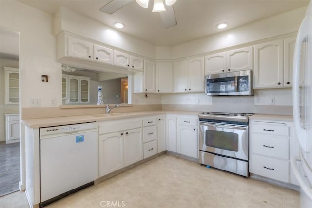 kitchen featuring white cabinets, a ceiling fan, stainless steel appliances, and a sink