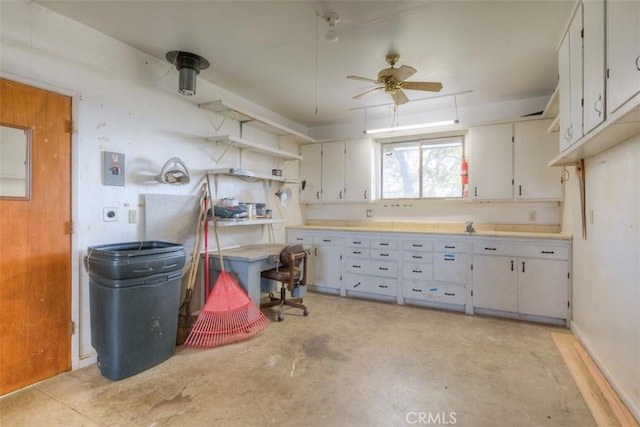 kitchen with white cabinets, light countertops, concrete flooring, and a ceiling fan