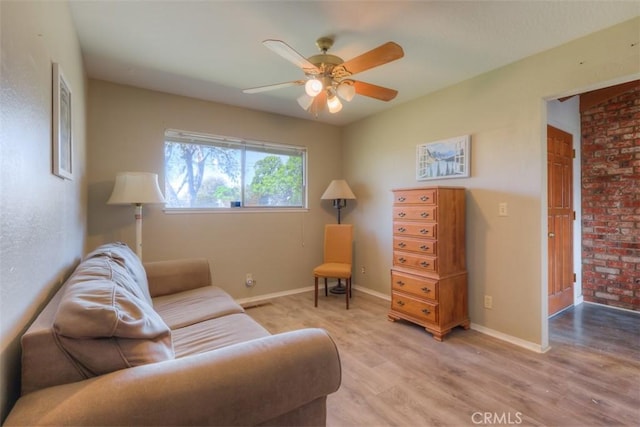 living room with light wood-style flooring, baseboards, and ceiling fan