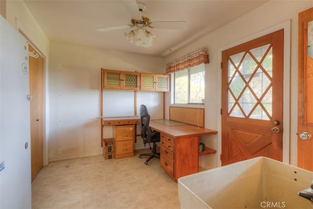 office space with light floors, ceiling fan, and baseboards