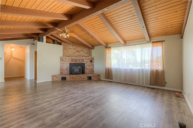 unfurnished living room with a ceiling fan, wood finished floors, lofted ceiling with beams, wood ceiling, and a brick fireplace