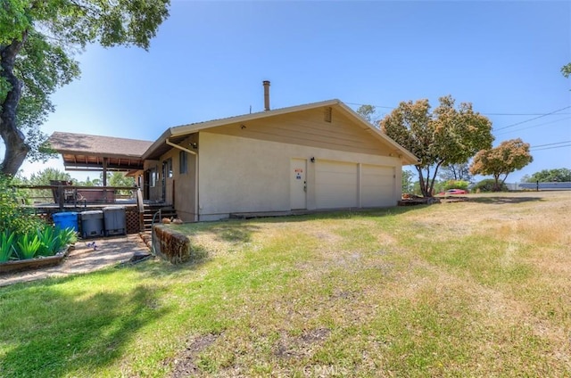 rear view of house featuring a yard and a garage