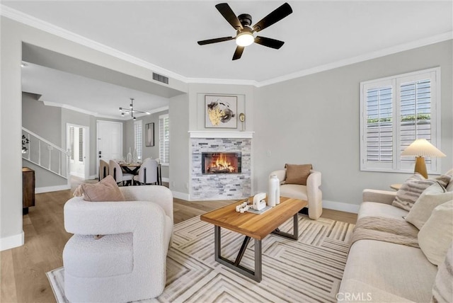 living area with baseboards, a tiled fireplace, visible vents, and plenty of natural light