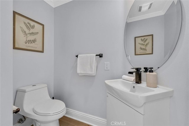 bathroom featuring toilet, crown molding, vanity, and visible vents