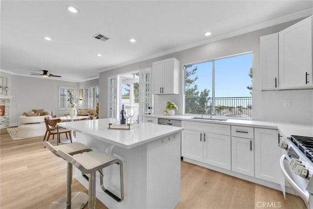 kitchen with visible vents, stainless steel gas range, ornamental molding, and a sink