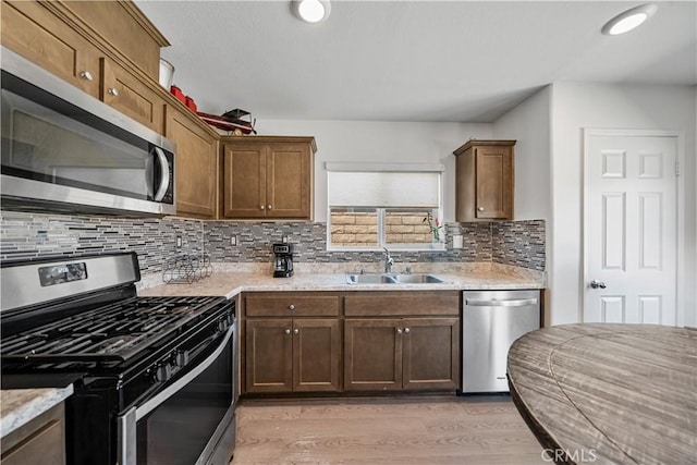 67410 Rio Vista Dr, Cathedral City, CA 92234 - kitchen with appliances with stainless steel finishes, a sink, light wood-style flooring, decorative backsplash, and light stone counters