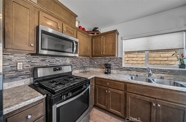 67410 Rio Vista Dr, Cathedral City, CA 92234 - kitchen featuring appliances with stainless steel finishes, a sink, decorative backsplash, and a textured ceiling