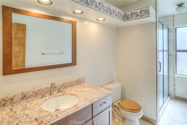 bathroom with toilet, vanity, and a stall shower