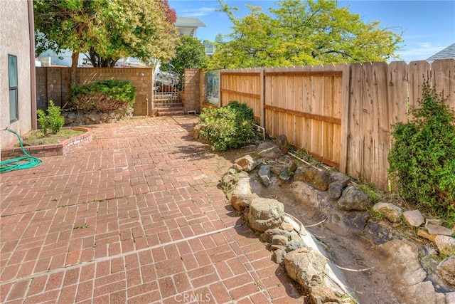 view of patio / terrace featuring a fenced backyard and a gate