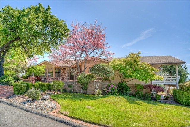 single story home featuring stucco siding and a front yard