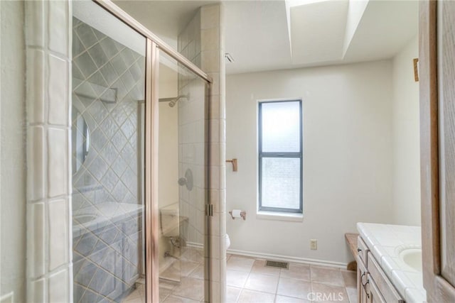 full bath with toilet, a stall shower, vanity, baseboards, and tile patterned flooring