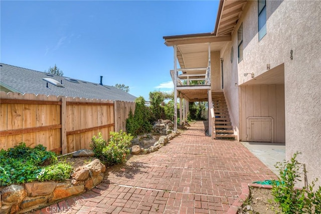 view of patio featuring stairway and fence