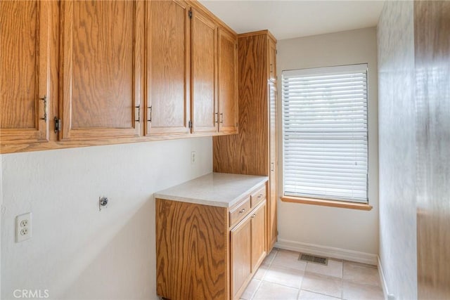 washroom with baseboards, visible vents, and light tile patterned flooring