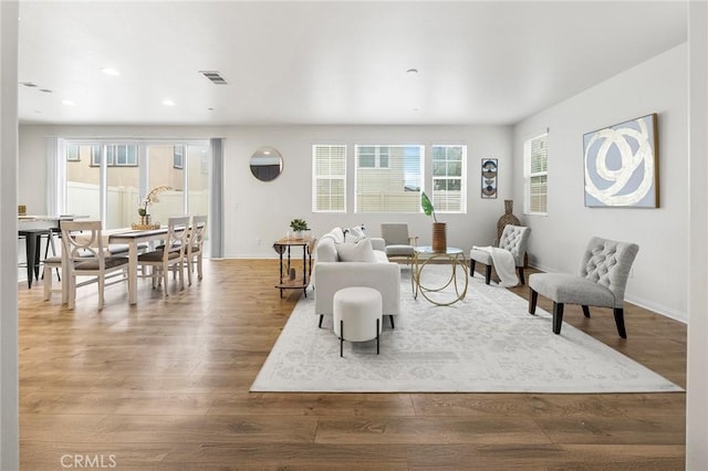 living area with baseboards, recessed lighting, wood finished floors, and visible vents