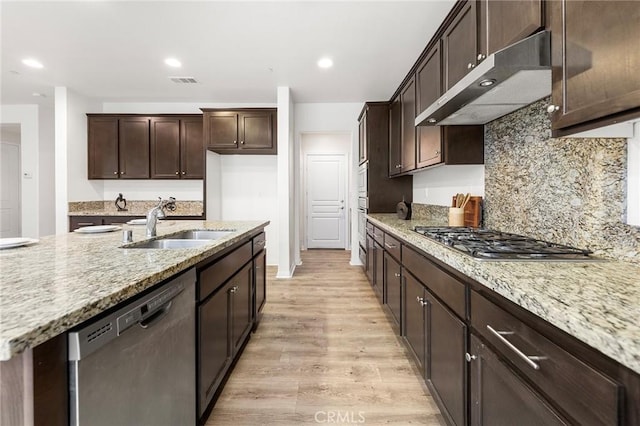 kitchen with dark brown cabinetry, a sink, light wood finished floors, stainless steel appliances, and under cabinet range hood
