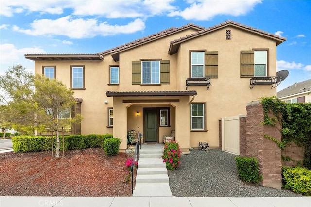 townhome / multi-family property with stucco siding and a tile roof