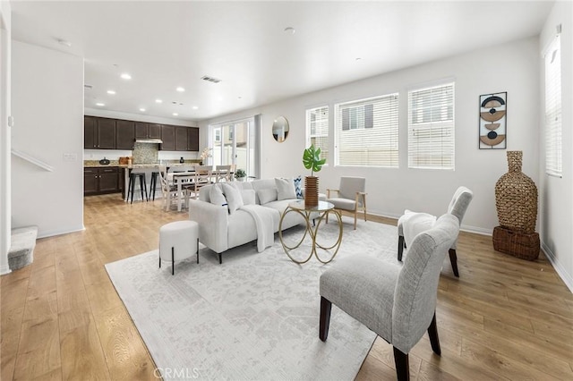 living area featuring recessed lighting, baseboards, light wood-type flooring, and visible vents