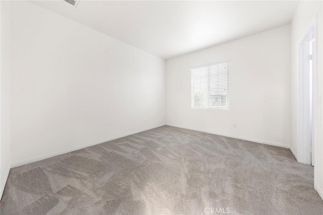 carpeted spare room featuring baseboards
