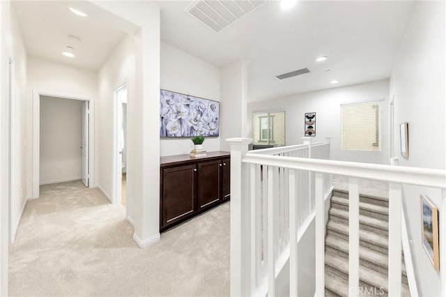 hallway with baseboards, light colored carpet, recessed lighting, and visible vents