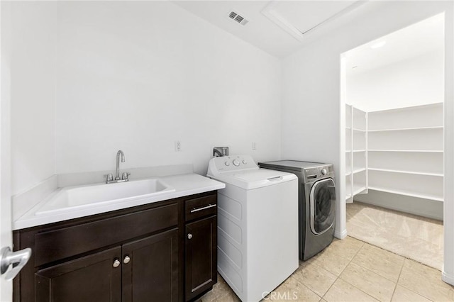 washroom with cabinet space, light colored carpet, a sink, separate washer and dryer, and visible vents