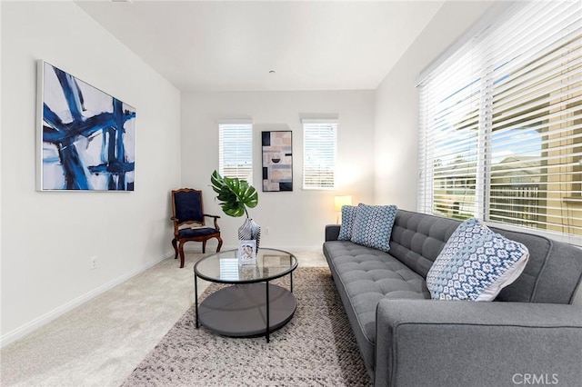 living area with carpet floors, baseboards, and a healthy amount of sunlight