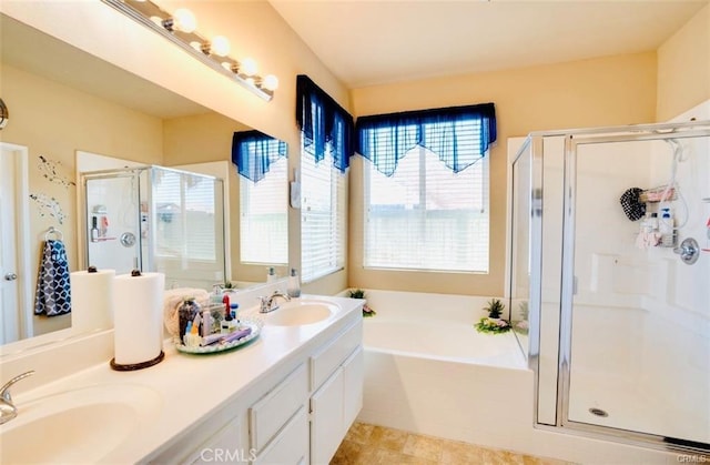 bathroom featuring double vanity, a bath, a stall shower, and a sink