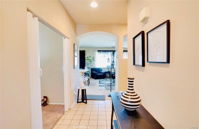 hall with recessed lighting, baseboards, arched walkways, and light carpet